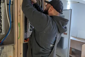 man installing breaker panel